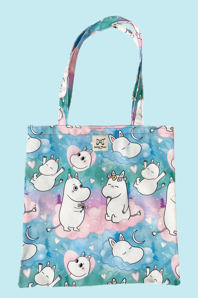 a pastel blue, green, purple and pink tote bag with clouds , moons, sparkles and cute Moomin print all over