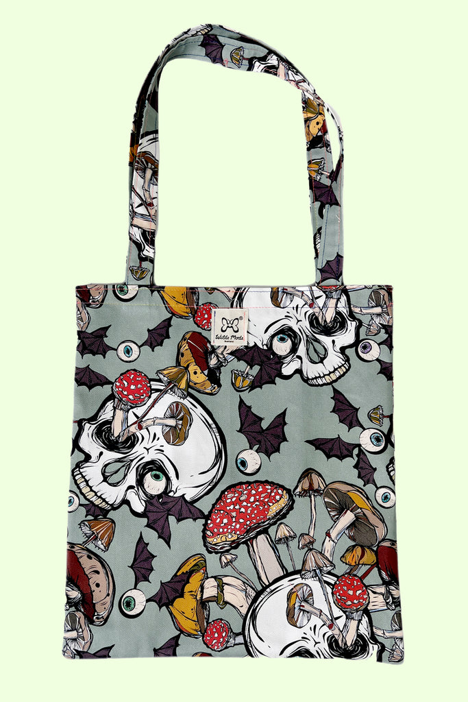 A mint green coloured tote bag with creepy mushroom print with skulls and eyeballs with bat wings