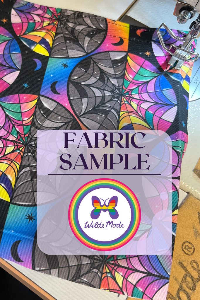 Enid and Wednesday Addams Windows print fabric shown next to a sewing machine with 'fabric sample' and Wilde Mode logo