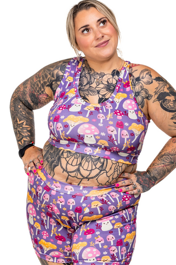 Woman wearing a colorful mushroom comfort top and boxers with a white background