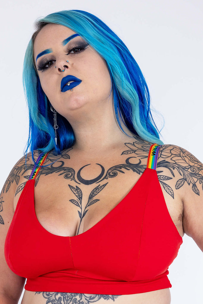 Model wearing Red Comfort Bra with Wilde Mode Rainbow Adjustable Slider Bra Straps. The straps are rainbow striped with 'Wilde Mode' written across them in black letters. 