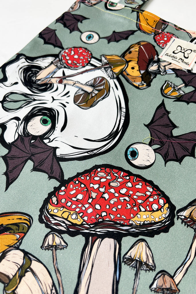 A mint green coloured tote bag with creepy mushroom print with skulls and eyeballs with bat wings